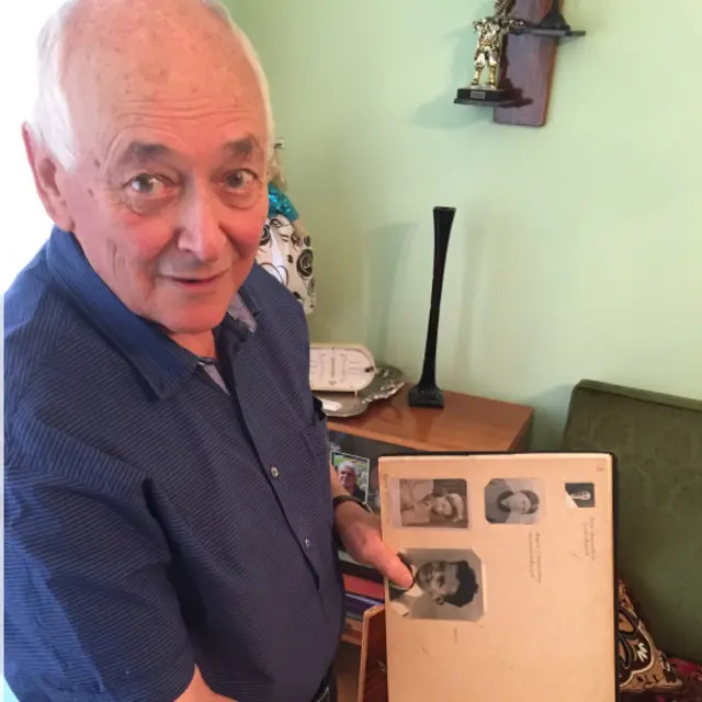 79-річний Василь Михайловський тримає у руках альбом зі своїми дитячими фото. Він вижив у Бабиному Яру