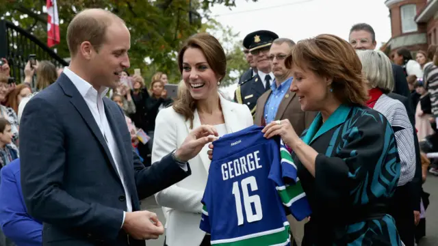 威廉王子和凯特王妃在慈善机构接受英属哥伦比亚省长赠送的乔治王子小球衣