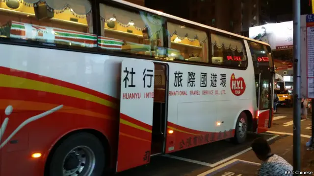 停留在夜市外头的陆客团游览车，陆客采买后相当迅速地上车。
