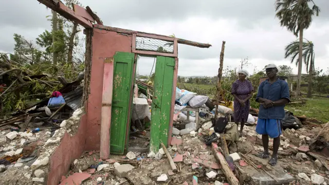 يقف سينتانور دوترفيل إلى جوار زوجته وسط أنقاض منزلهما الذي دمر في ليه كاييه، غربي هايتي. وقد لاذ الكثير من المواطنين بملاجئ حكومية.