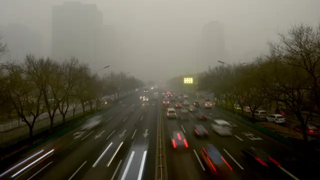 雾霾严重的一段北京大街汽车川流不息(资料图片)