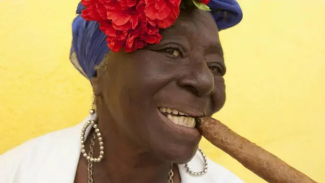 古巴老妇人叼着雪茄对着游客摆姿势（图片来源：Getty Images）