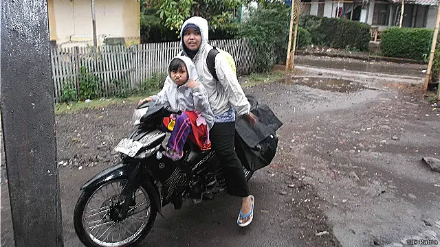 Elis beserta anaknya menaiki motor yang biasa dipakai sebagai perpustakaan keliling.