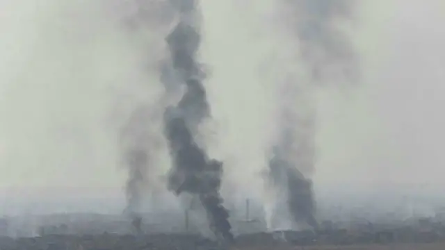 الدخان تصاعد من بلدة برطلة التي تخضع لسيطرة تنظيم الدولة الإسلامية خلال اشتباكات بين القوات العراقية ومسلحي تنظيم الدولة يوم الثلاثاء