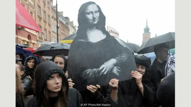 在席卷波兰全国的“黑色星期一”罢工中，华沙妇女举着《蒙娜丽莎》的复制品抗议一项全面禁止堕胎的立法提案（图片来源：美联社照片/Alik Keplicz）
