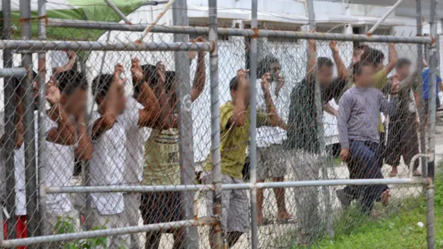 寻求政治庇护者在马努斯岛拘留中心的围篱后面。