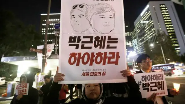 प्रदर्शनकारीहरुले राष्ट्रपति पाक र उनकी मित्र चोय सुन शीलको तस्वीर बोकेका छन् 