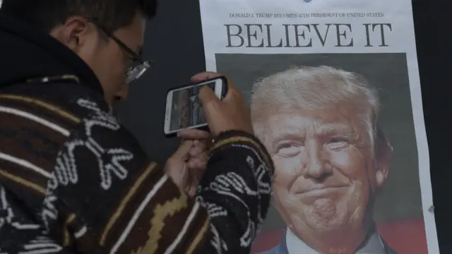 上海一个民众用手机拍摄有特朗普照片的报纸