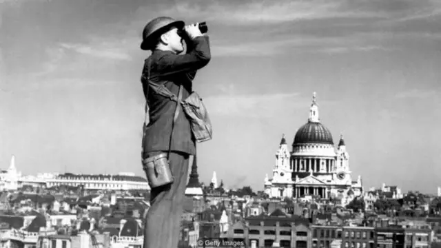 一名空袭观察员在闪电战时观看伦敦天空——当时圣保罗大教堂耸立在城市之巅（图片来源：Getty Images)
