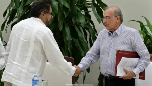 哥伦比亚革命武装力量首席谈判代表马克斯(左)与哥伦比亚政府首席谈判代表迪拉卡利(右)在哈瓦那签订第二份和约后握手(12/11/2016)