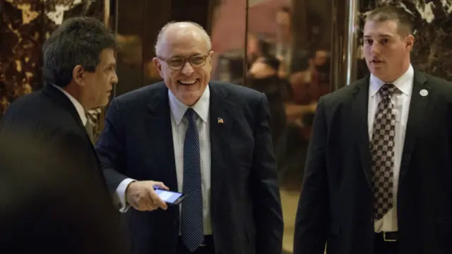 Former New York Mayor Rudy Giuliani, center, smiles as he leaves Trump Tower, Friday, Nov. 11, 2016, in New York. (AP Photo/Evan Vucci)