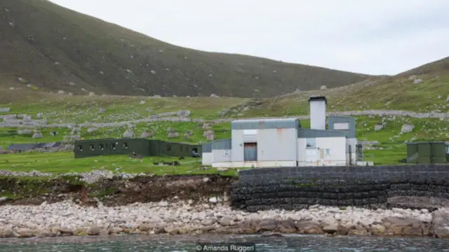 从赫塔岛的港口望去，由国防部管理的军事设施让村落遗迹相形见绌（图片来源：阿曼达·鲁杰里）