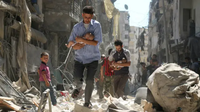 叙利亚男子抱着婴儿走过废墟