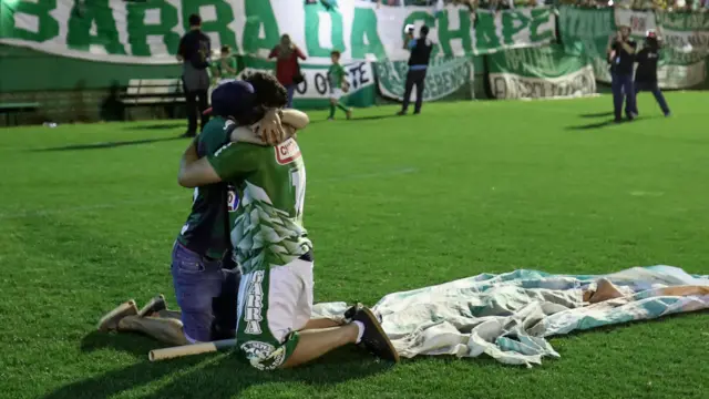 兩名沙佩科恩斯球迷在草地上互相擁抱