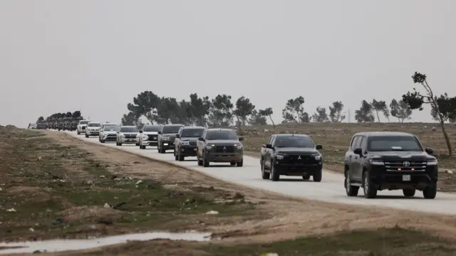 Arazi araçları ve dört çarpı dörtlerden oluşan bir konvoy bir ana yoldan ilerliyor, onlarca araç var. 