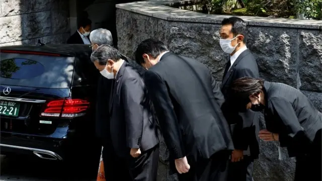 People paid their respects as the car carrying the body of Shinzo Abe arrived at his home in Tokyo