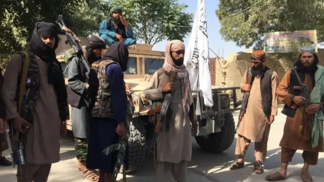 মাজার ই শরিফ শহরের কাছে আফগান সৈন্যদের কাছ থেকে দখল করা আমেরিকান একটি হামভি সাঁজোয়া যান ঘিরে কয়েকজন তালেবান যোদ্ধা