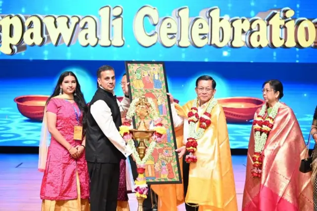 အောက်တိုဘာ ၁၇ ရက်ညက အမျိုးသားကဇာတ်ရုံမှာပြုလုပ်တဲ့ ဒီပါဝလီပွဲကိုတက်လာတဲ့ စစ်ခေါင်းဆောင်နဲ့ ဇနီး က အမှတ်တရပစ္စည်းလက်ခံရယူတဲ့မြင်ကွင်း 