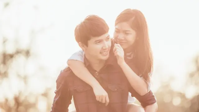 Una joven a punto de pellizcar la mejilla de un joven