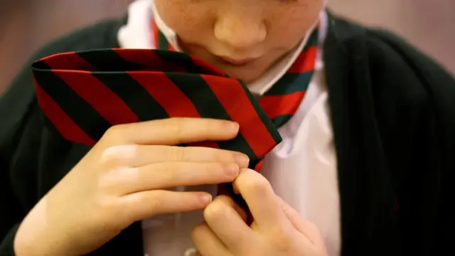 девочка повязывает школьный галстук