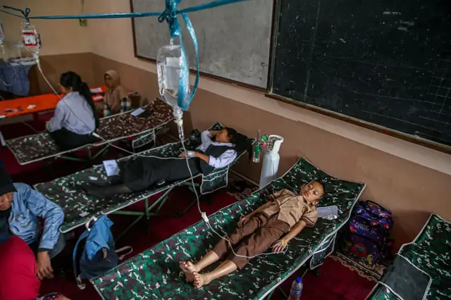 Para siswa beristirahat di tempat tidur portabel sambil menerima perawatan akibat keracunan makanan setelah mengonsumsi makanan sekolah gratis bersubsidi pemerintah di SMPN 1 Cisarua, Kabupaten Bandung Barat, Jawa Barat, Indonesia, pada 15 Oktober 2025. Menurut data awal, 300 siswa dari sekolah dasar, sekolah menengah pertama, dan sekolah kejuruan mengalami keracunan makanan, yang diduga disebabkan oleh konsumsi makanan bergizi gratis pada Selasa pagi, 14 Oktober 2025. (Foto oleh