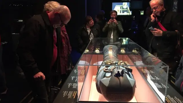 الزوار يلقون نظرة على أحد التوابيت