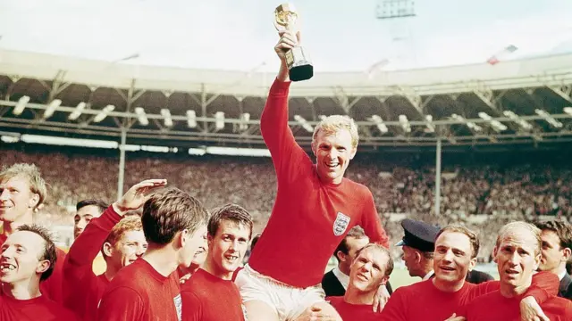 Bobby Moore, en el centro, aupado por sus compañeros de equipo, alza con su mano derecha el trofeo.