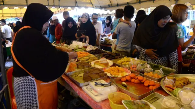 Wadansu Musulmi lokacin da suke kokarin sayen abincin buda baki a wata kasuwa da ke lardin Narathiwat na kasar Thailand a ranar Alhamis