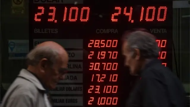 Dos hombres pasando frente a una casa de cambio en Buenos Aires.