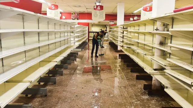 Un hombre limpia un supermercado asaltado