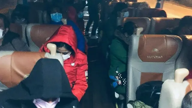 একটি বাসে করে উহানের বিমানবন্দরে নিয়ে যাওয়া হচ্ছে ঢাকায় ফিরতে আগ্রহী বাংলাদেশিদের।