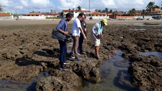 Pessoas observam manchasbettingfanspetróleo na praia