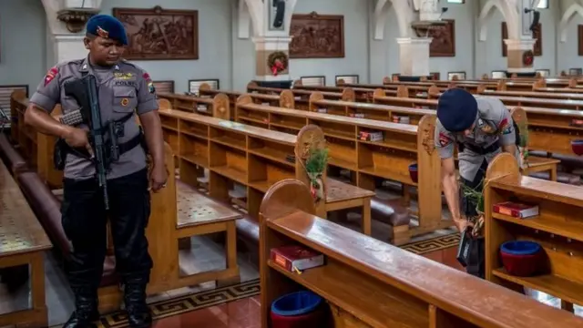 Polisi memeriksa gereja di Surabaya pada malam Natal.