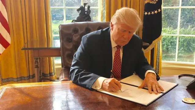 Donald Trump firma un documento