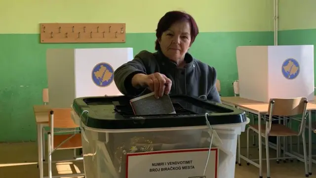 Žena ubacije glasački listić u plastičnu kutiju