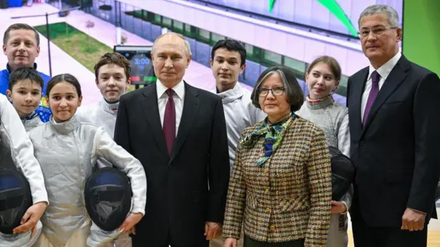 Путин стоит с группой детей и губернатором