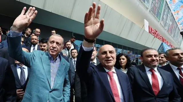 Erdoğan Turgur Altınok ve diğer partililer Keçiören yazılı bir binanın önünde halkı selamlıyor. 