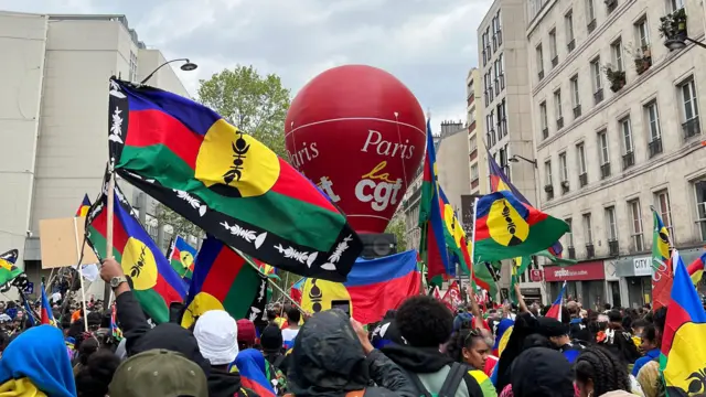 Demonstran membawa bendera Kaledonia Baru di Paris. 