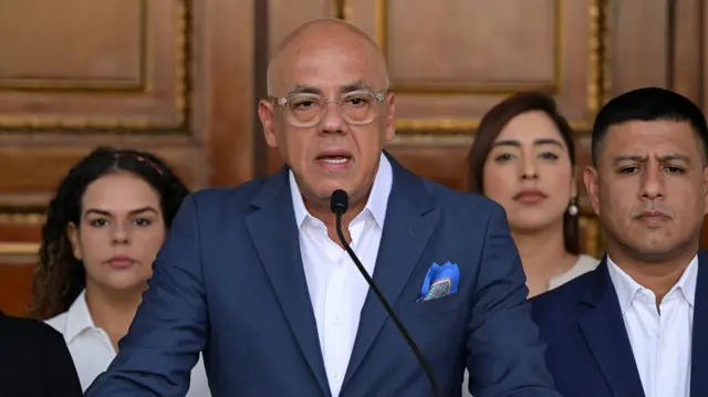 El líder de la Asamblea Nacional de Venezuela, Jorge Rodríguez, hace un anuncio, con tres personas a su alrededor