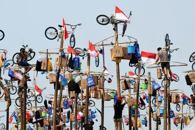 Para peserta mengikuti Panjat Pinang—lomba memanjat tiang—sebagai bagian dari perayaan HUT ke-72 Kemerdekaan Indonesia di Pantai Ancol, Jakarta, pada 17 Agustus 2017.