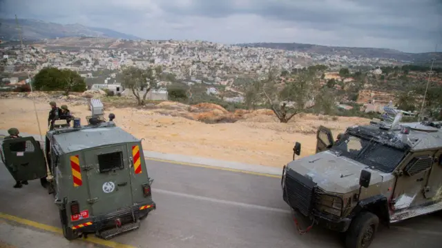 الصورة التقطت نهاراً لمركبتين عسكريتين إسرائيليتين في بلدة بيتا