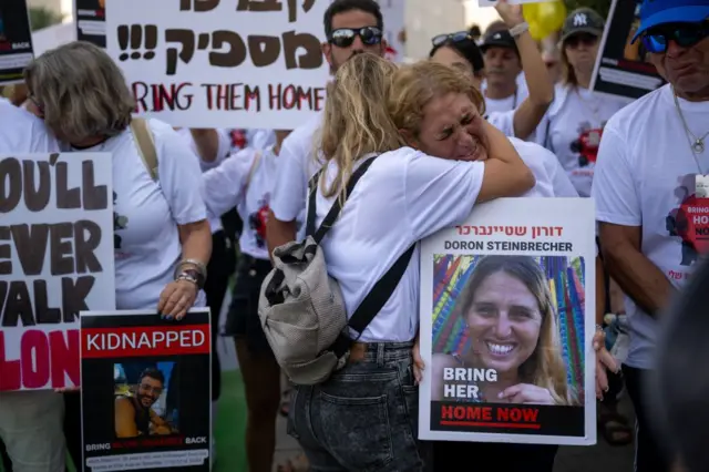 Duas mulheres se abraçam enquanto choram em um protesto pelas pessoas que foram sequestradas pelo Hamas