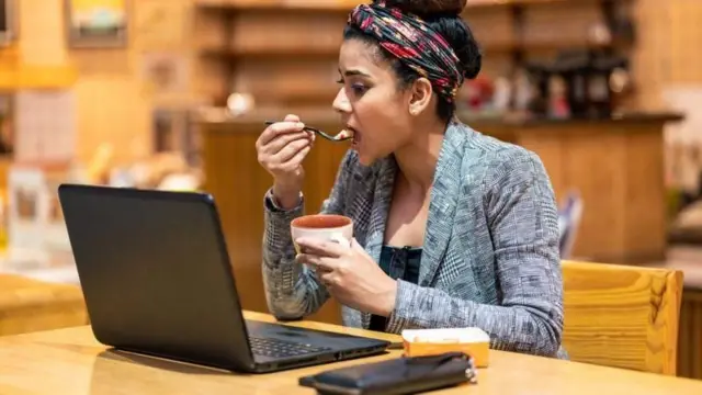 लॅपटॉपवर काम करत असलेली महिला