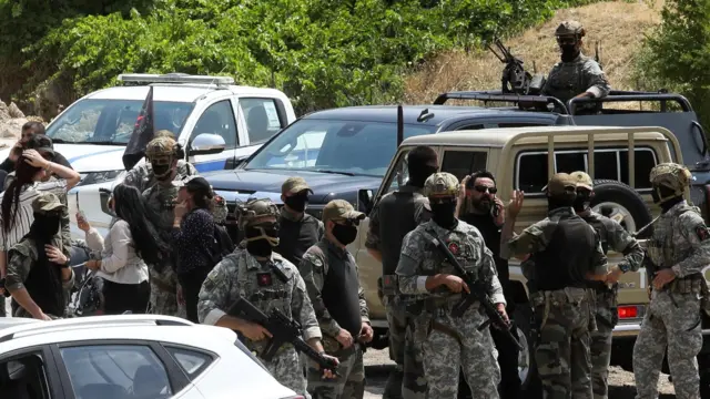 قوات الأمن كردية تقف عند نقطة تفتيش، في يوم حفل نزع سلاح مقاتلي حزب العمال الكردستاني، قرب السليمانية