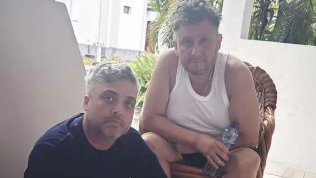Carlos Rodelo y Jorge Cubillos sentados afuera de su habitación en un hotel en Kinshasa, capital de la República Democrática del Congo.