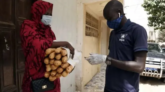 Une femme tenant des miches de pain
