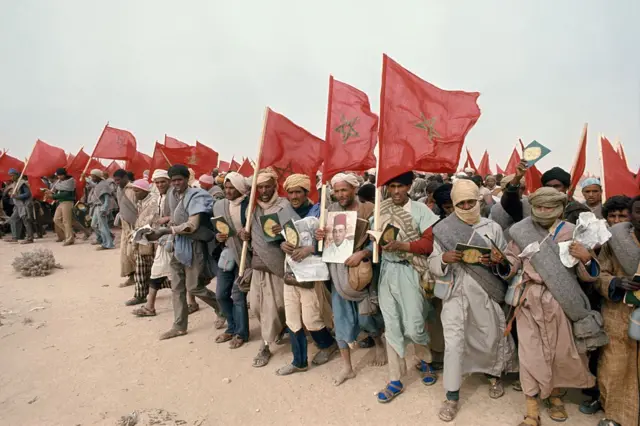 Civiles marroquíes portan banderas nacionales, ejemplares del Corán y retratos del rey Hassan II durante la Marcha Verde de noviembre de 1975, con la que Rabat presionó a España para que abandonara el Sáhara Occidental.