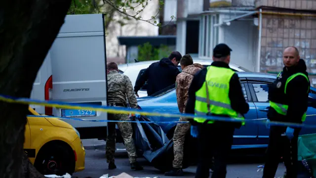 Сотрудники экстренных служб несут тело одной из жертв нападения