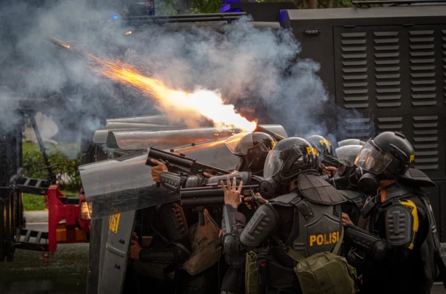 Personel kepolisian menembakkan gas air mata ke arah pengunjuk rasa di depan Mapolda Jateng, Kota Semarang, Jawa Tengah, Jumat (29/8/2025).