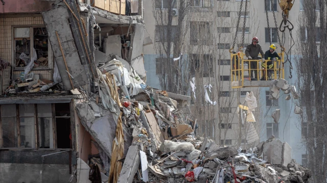 Socorristas removem destroços de um prédio de vários andares muito danificado após um ataque de drone, em Odesa.